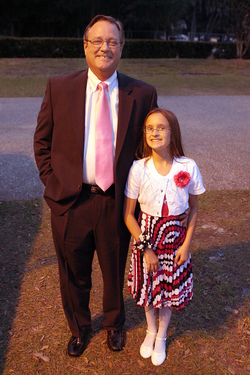 Wray and Cadie, 9, Williams pose together before heading into the father-daughter dance, Friday, Feb. 3, at St. Marthaâ€™s.