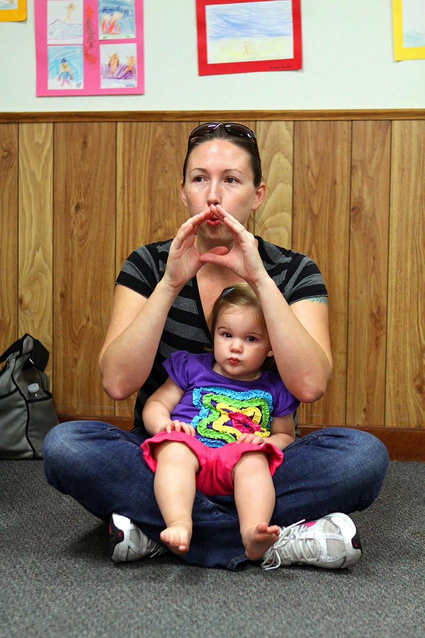 Deseray Jones makes the sign for â€œballoonâ€ while her daughter, Ava, 15 mos, sits in her lap.