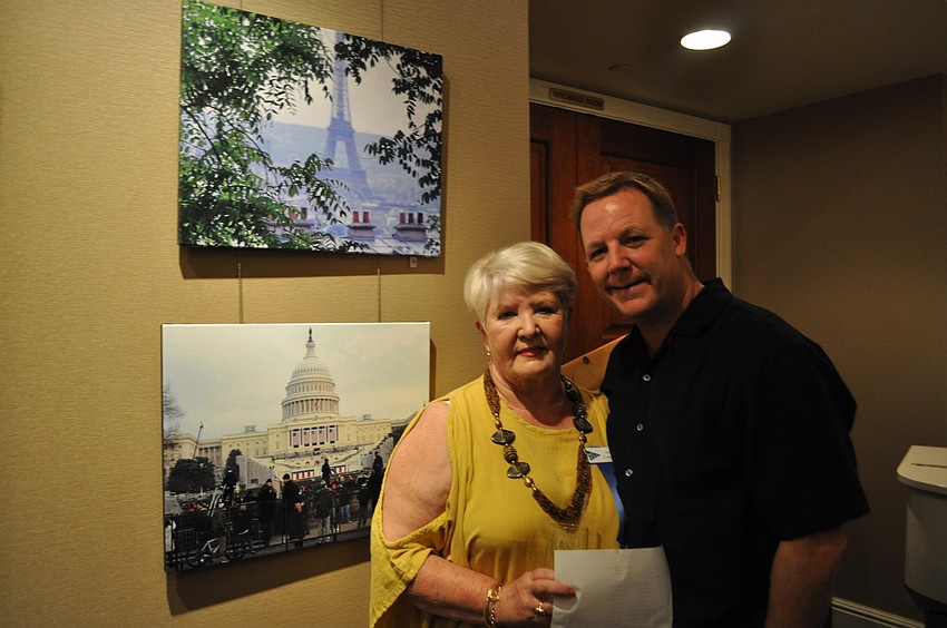 Jeri Cushman and her son Chris Cushman in front of her photographs â€œView from a Hillâ€ and â€œPreparing for History.â€