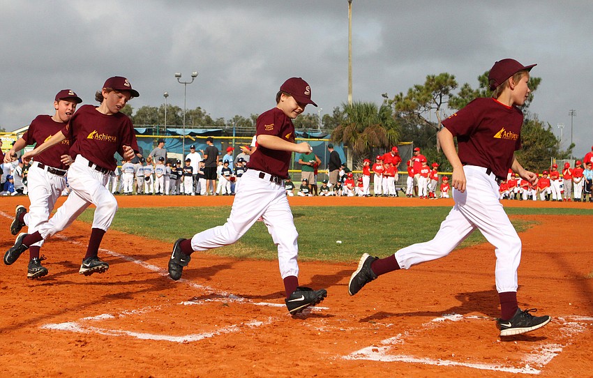 Achieva Maroon run from third base and cross home plate during the opening day ceremony, Saturday, Feb. 18.