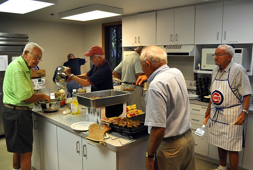 Some of the men in the Men's Fellowship help to make breakfast, Tuesday, Feb. 28, in the kitchen at the Fellowship Hall at Siesta Key Chapel.