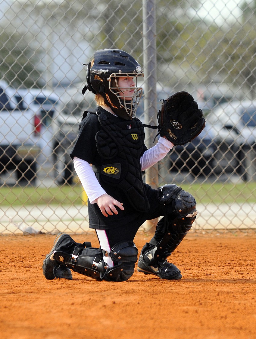 Six-year-old catcher Kiera Caffrey is playing softball for the first time this spring.