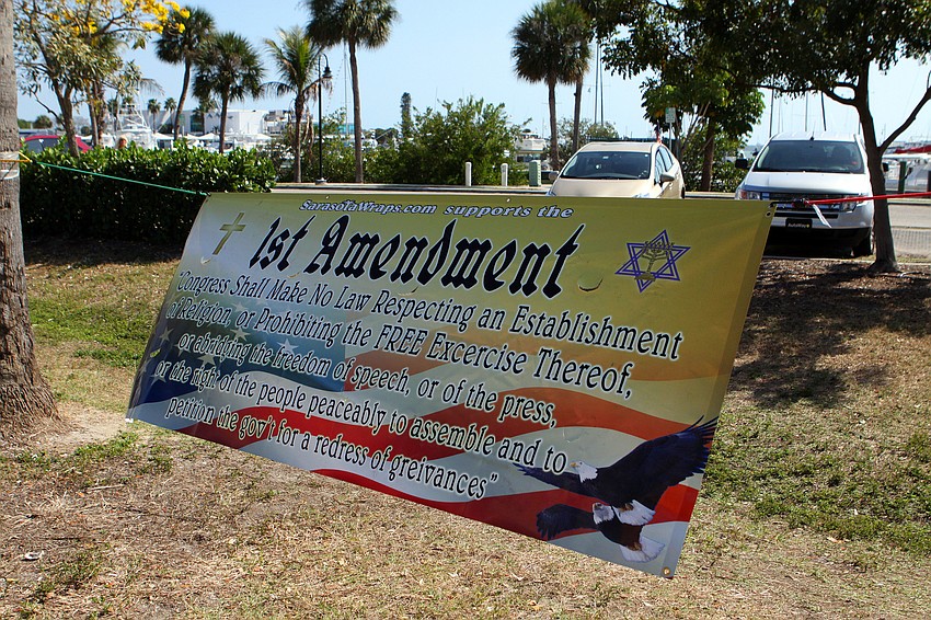 A banner waving information about the 1st Amendment was hung up between two palm tress along 41 by the Kissing Statue, Friday, March 23.
