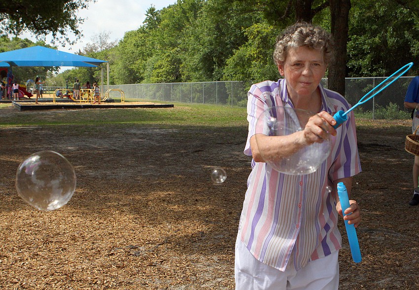 Verlie Bradley has fun playing with one of the bubble wands, Saturday, March 31, at the Face Autism Egg Hunt at Ashton Elementary.