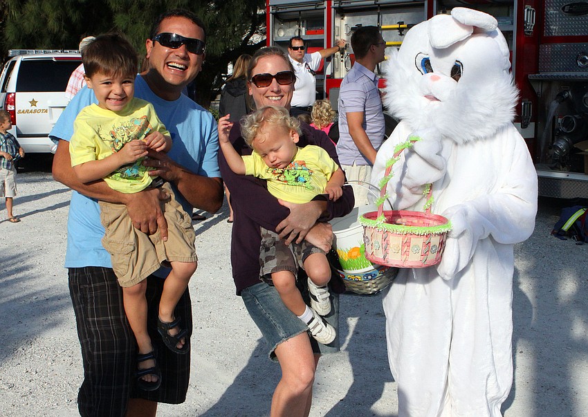 Tristan and Jessica Bangora held their sons TJ, 3, and Ryan, 1, up to pose with the Easter Bunny, Saturday, April 7, at the SKVA Easter Egg Hunt.