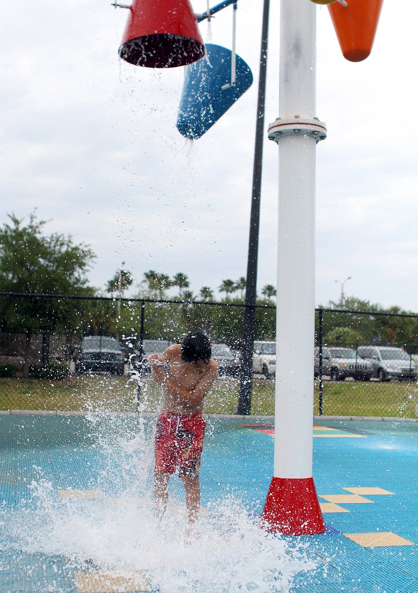 Angelo Lopez, 8, gets water dumped on him at the water park.