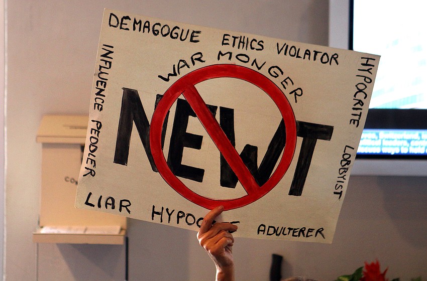 A woman holds up a sign out in the lobby of Dolphin Aviation as people file out after the Newt Gingrich rally, Tuesday, Jan. 24.