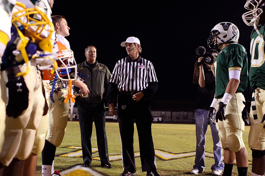 The captains for the Manatee All-Stars, left, and the Sarasota All-Stars, right, listen to the referee prior to the coin toss.