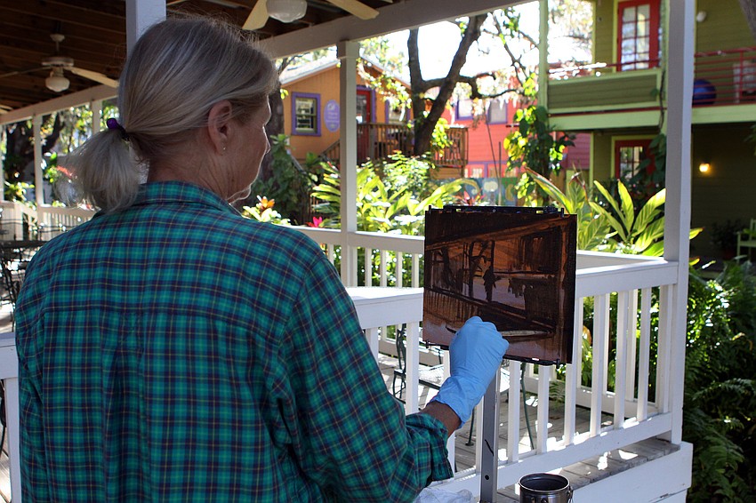 Suzi Bethke, of Osprey, has a good time painting, Thursday, Jan. 12, in Towles Court with the rest of the Plein Air Sun Coast artists.
