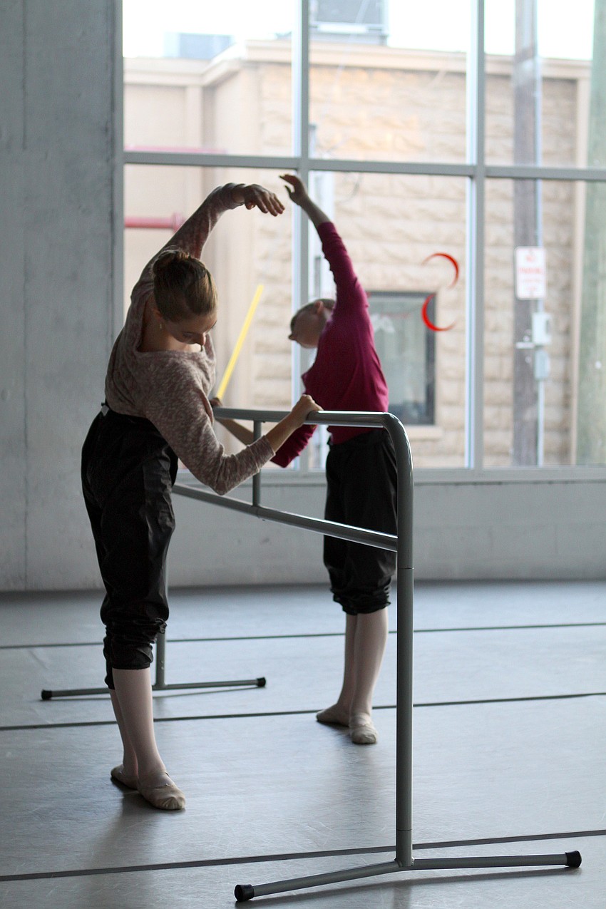Nikki Jennings, 14, and Caitlin Gish, 13, warm up at the barre inside Studio 20.