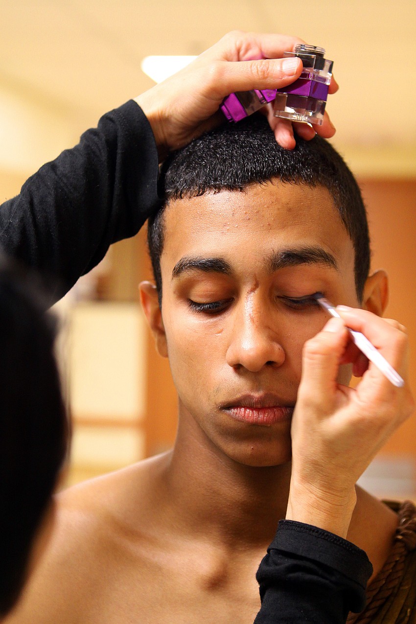 Isabel Dubrocq puts some eyeliner on Yamil Maldonado prior to his performance.