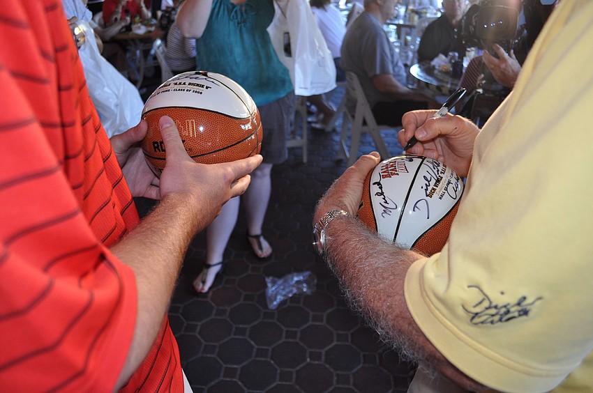 Dick Vitale signs two basketballs for Michael Fear.