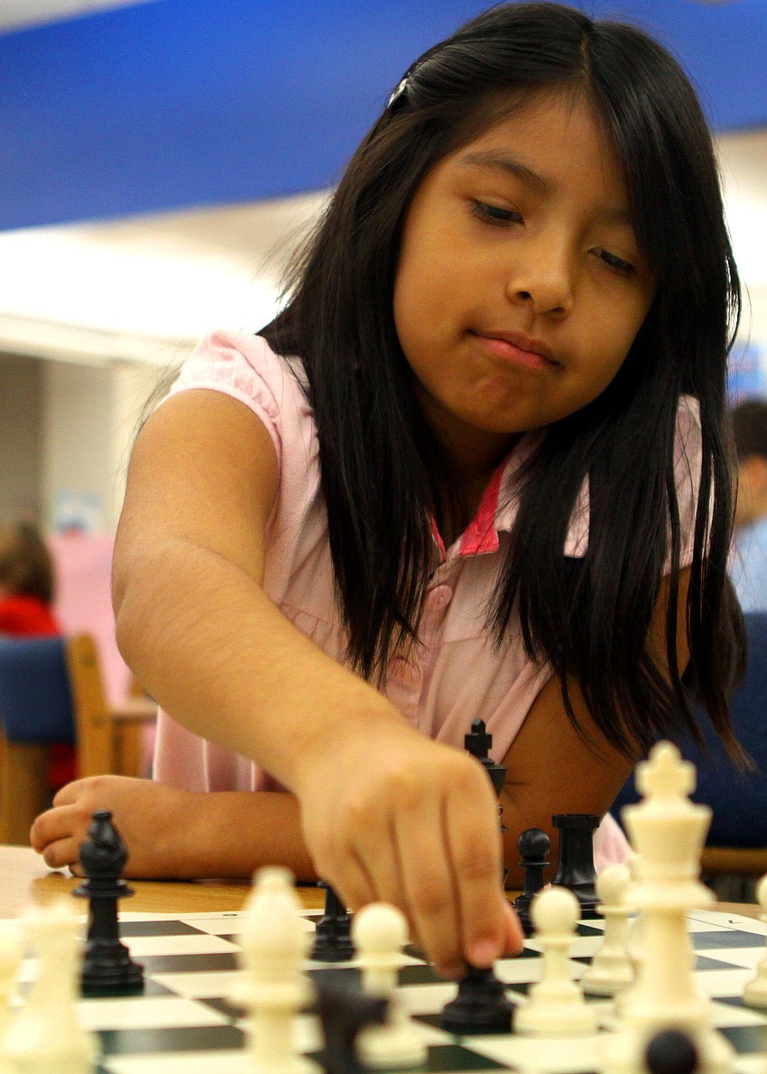 Vanessa Aparicio makes a move during her chess match, Saturday, Feb. 11, in the library at Phillippi Shores Elementary.