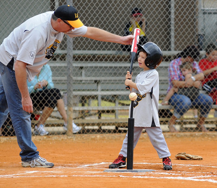 Four-year-old Henry Urban receives some batting advice from his coach.