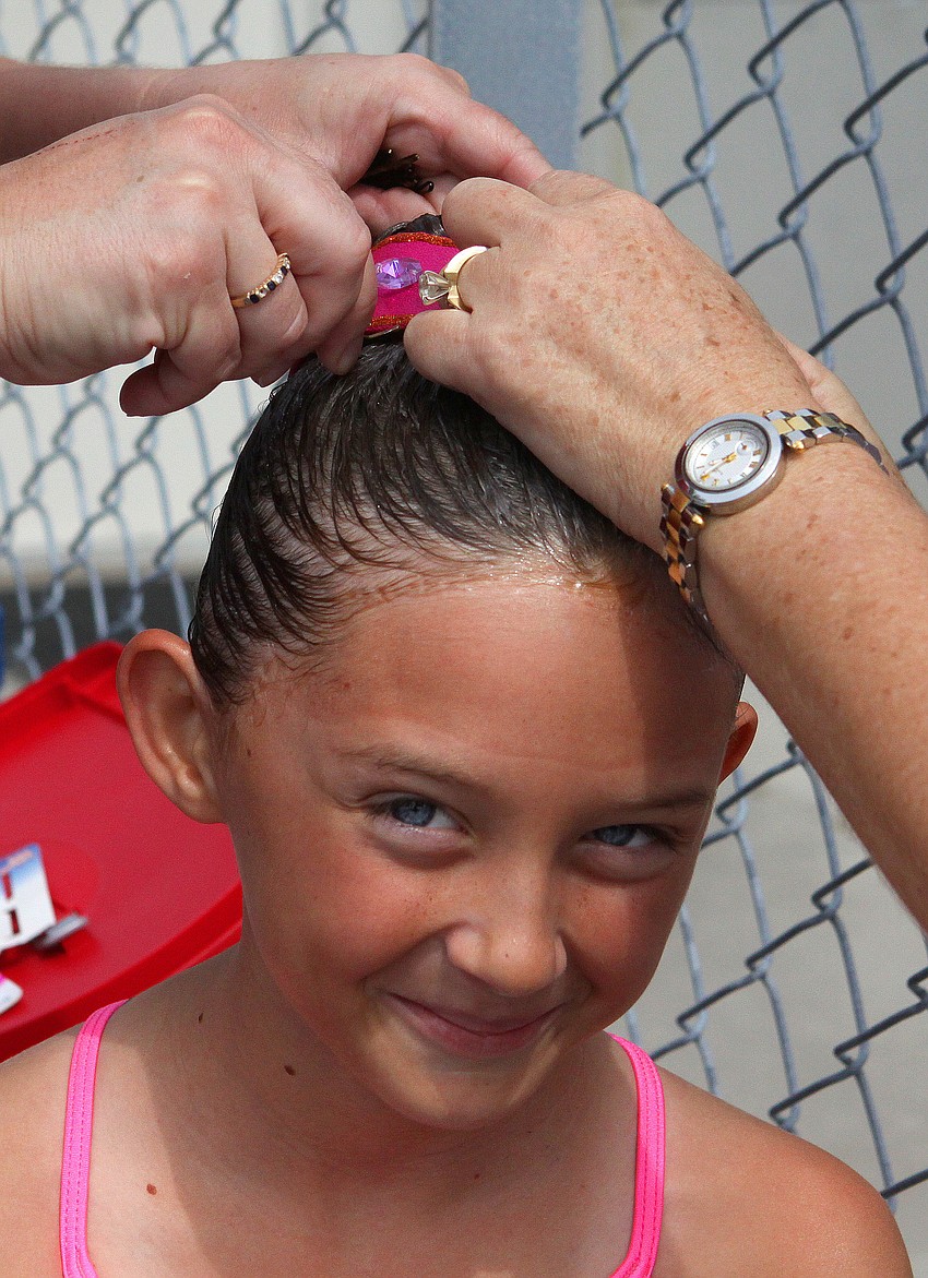 Elaine Borges gets some help having her headpiece pinned into her hair.