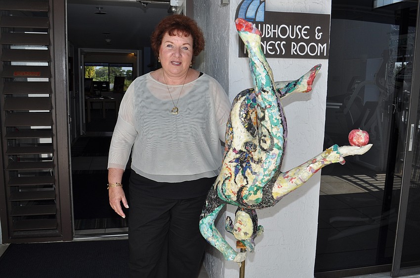 Maxine Tauber organized the event. She is standing in front of a sculpture made by resident Marv Levitt