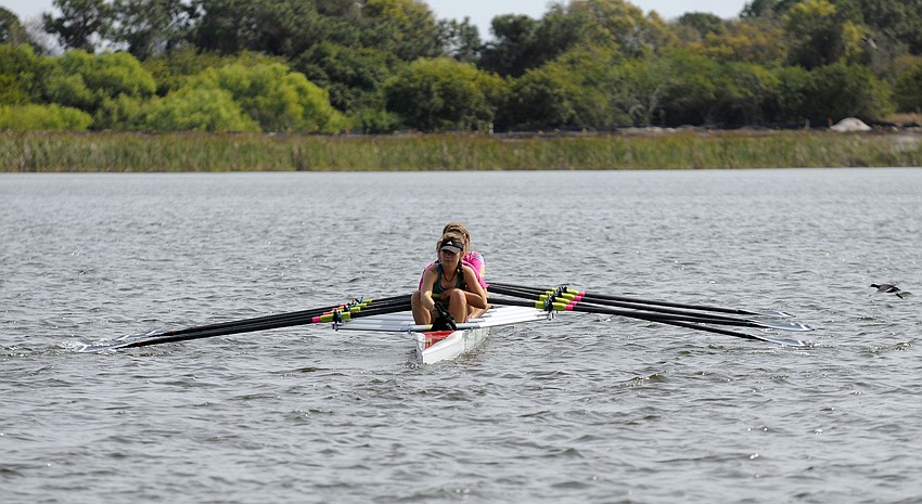 Members of the Sarasota Scullers crew team head out into the water for the start of their race.
