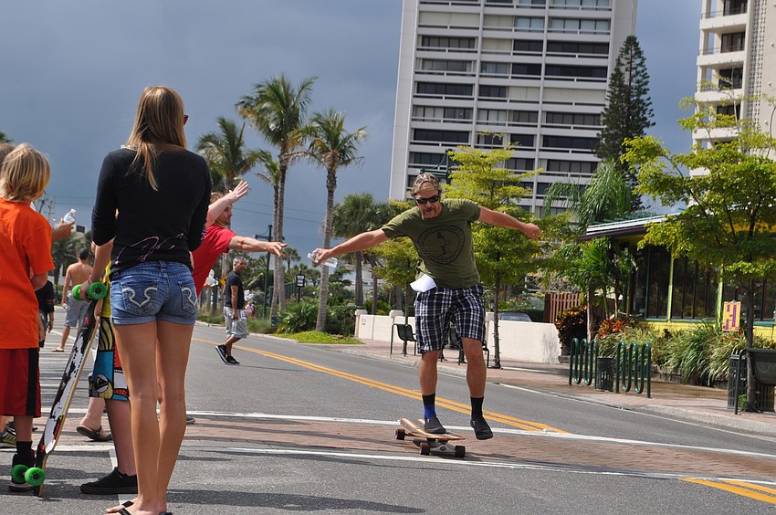 Mike Case grabs a bottle of water as he finishes the first lap around Siesta Key Village.