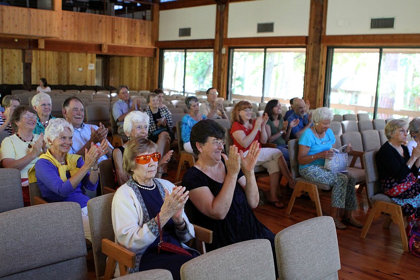 The crowd claps after Dr. Zachary Johnson finishes playing a piece on his guitar, Sunday, March 25, at Siesta Key Chapel.