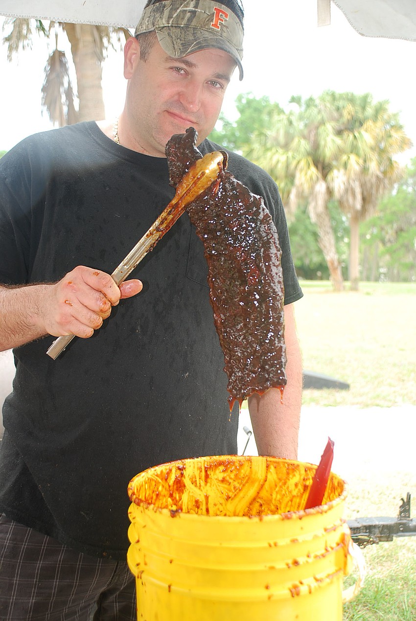 Donnie Taylor dunks the ribs in the homemade BBQ sauce
