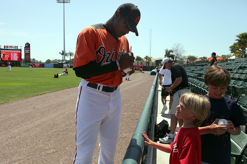 Adam Jones signs balls for Grant Anderson, 8, and Ethan Anderson, 10, before the charity baseball game against SCF, Tuesday April 3.