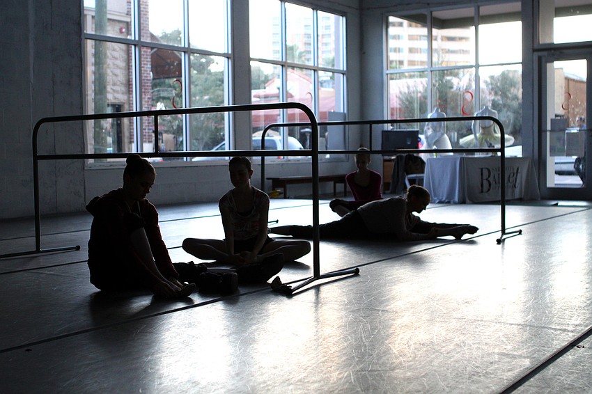 The girls put on their shoes and stretch out on the floor prior to rehearsal, Friday, Jan. 6, at Studio 20.