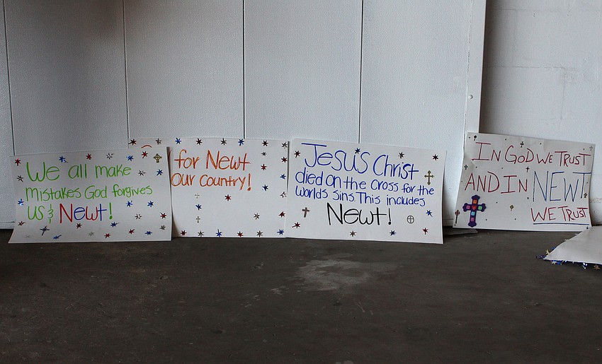 Homemade signs were lined up against a wall at Dolphin Aviation and were held up during the rally.