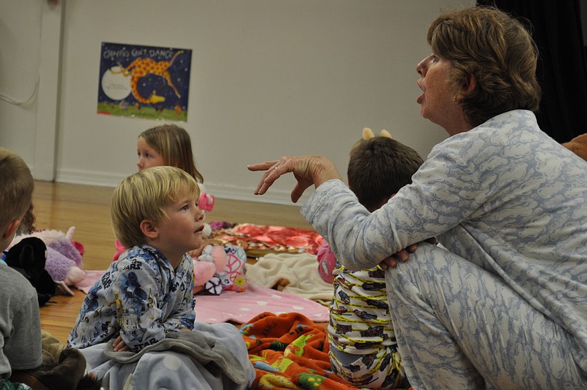 Landon Fluimefreddo listens as ODA librarian Glendry Huene tells a story.
