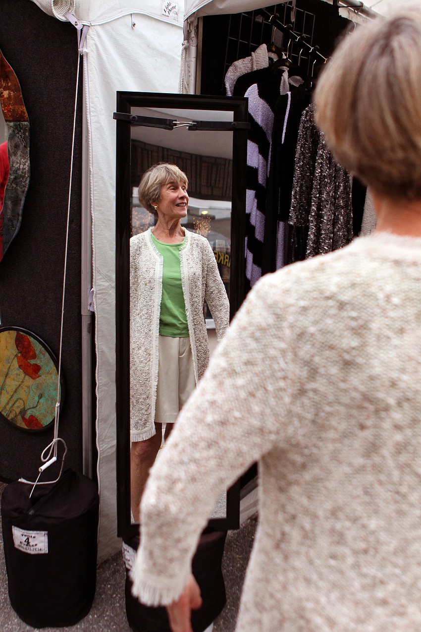 Carolyn Ehrman tries on a sweater made by Heidi Hess of Fiberology.