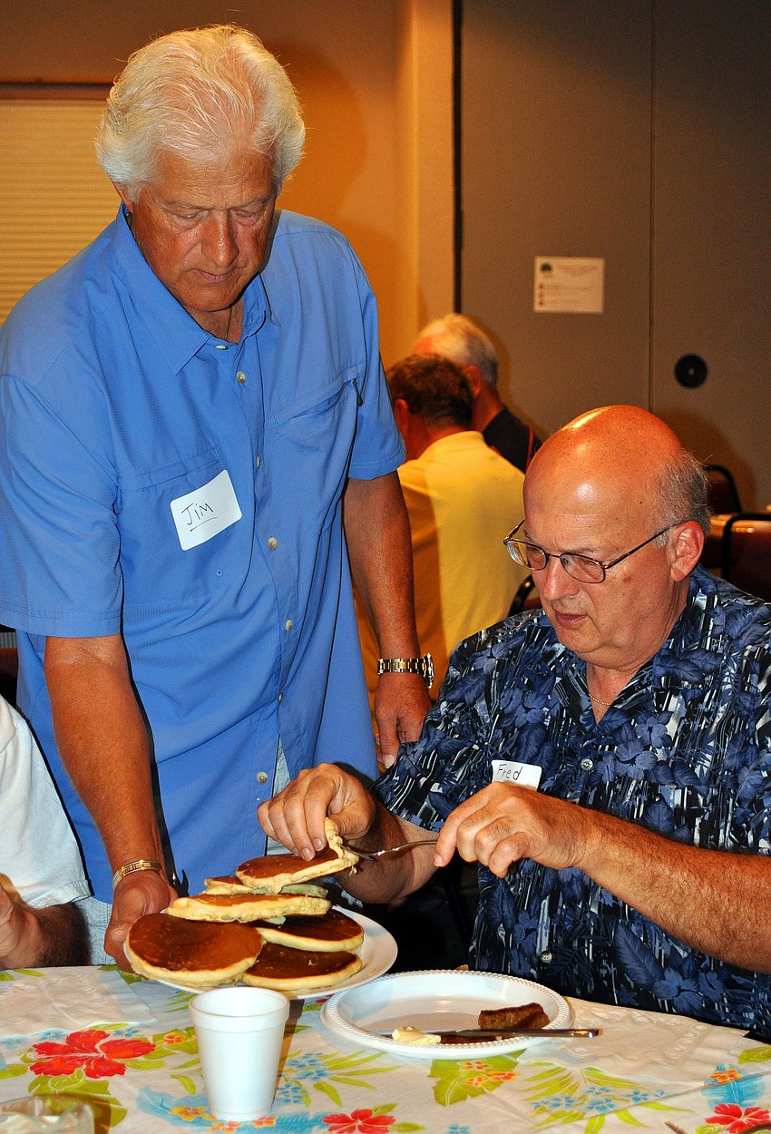 Fred Teeter gets a pancake off a plate held out by Jim Hastings, Tuesday, Feb. 28.