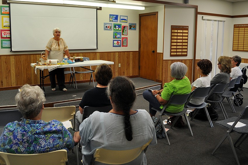 Tetiana Silecky wipes off the excess bees wax from her egg at the end of her demonstration at the Gulf Gate Library on Tuesday.