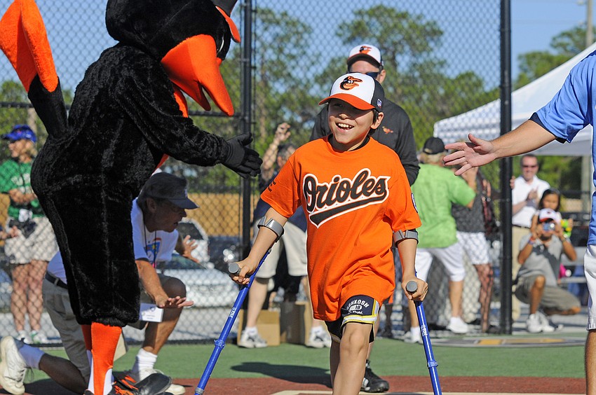 Eleven-year-old Santiago Huertas is congratulated after scoring a run for the Orioles.