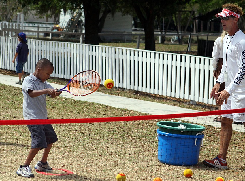 Nissi Luvavali, 7, hits a backhand while Coach Dave Villani watches, Tuesday, March 20, out at New Gate.