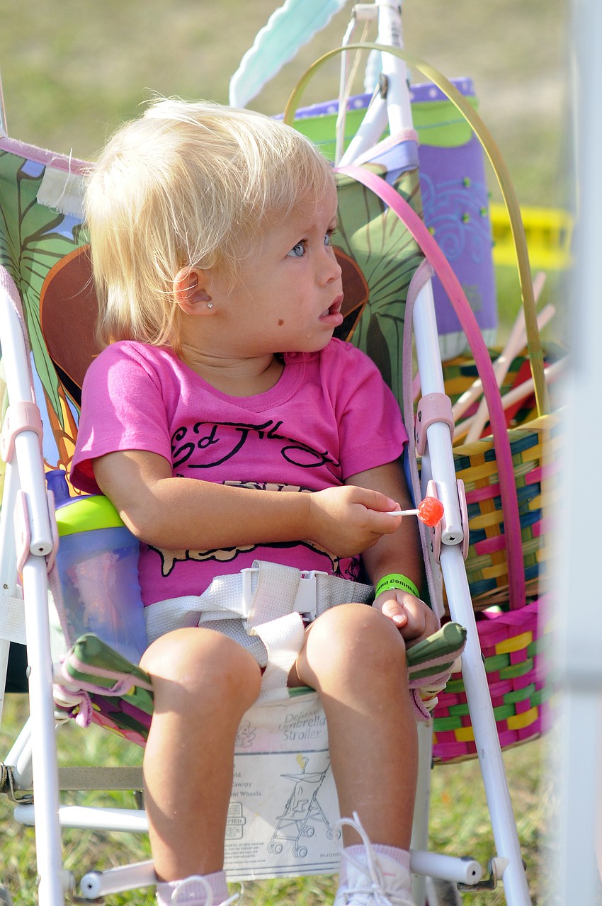 One-and-one-half-year-old Chloe Munns sits patiently watching as her mom Shana makes her necklace.