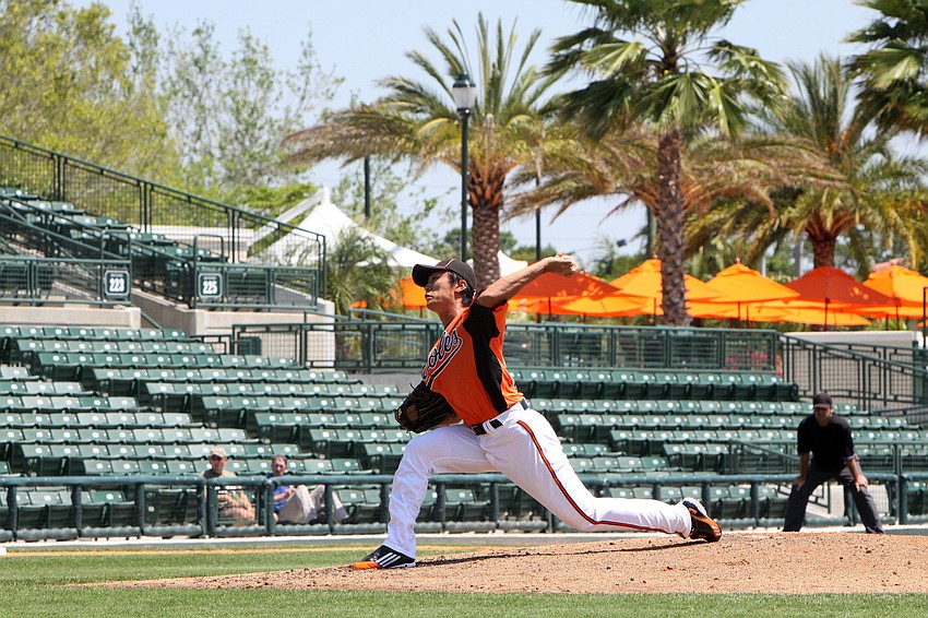 Tsuyoshi Wada pitches towards home plate.