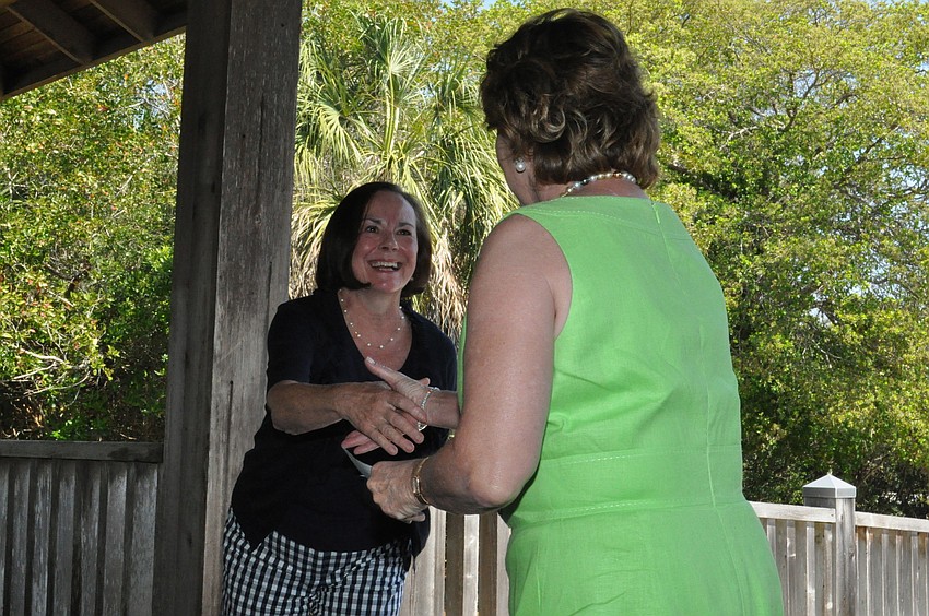 Vicki Lyons presents Gail E. Hanna, president of the Manatee County Girlâ€™s Club Foundation, with a $1,000 check.