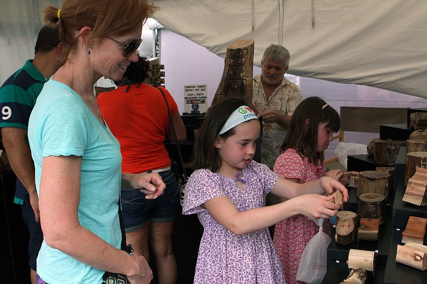 Mary Beth Canfieldâ€™s daughters, Megan, 7, and Molly, 9, have fun finding all of the secret hiding places inside Camphor Unique Secret Art Boxes, Saturday, April 14, at Siesta Fiesta.