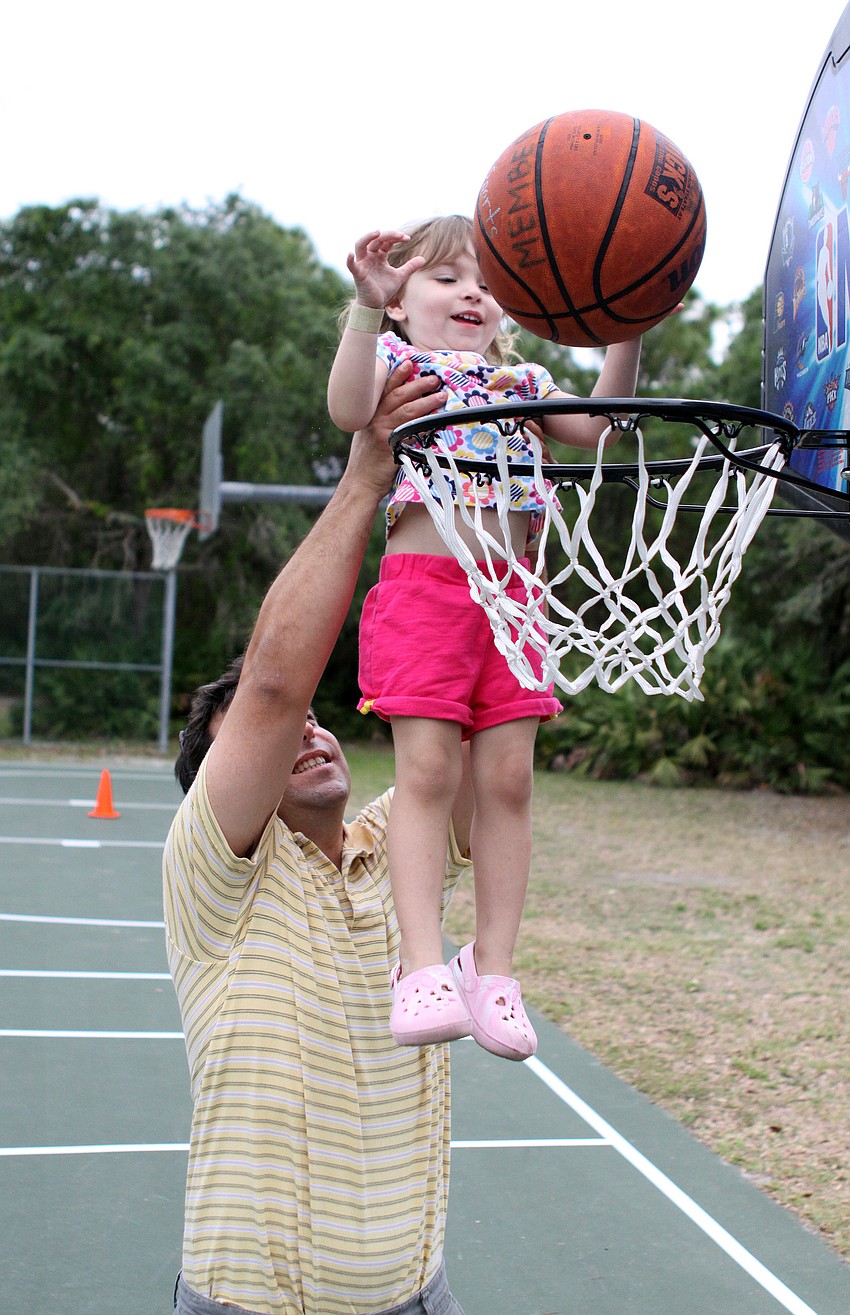 Mark Schwartz helps his daughter, Sadie, 3, score a basket.