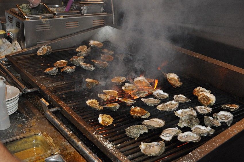 Oysters cook on the grill at the Half Shell's opening party.