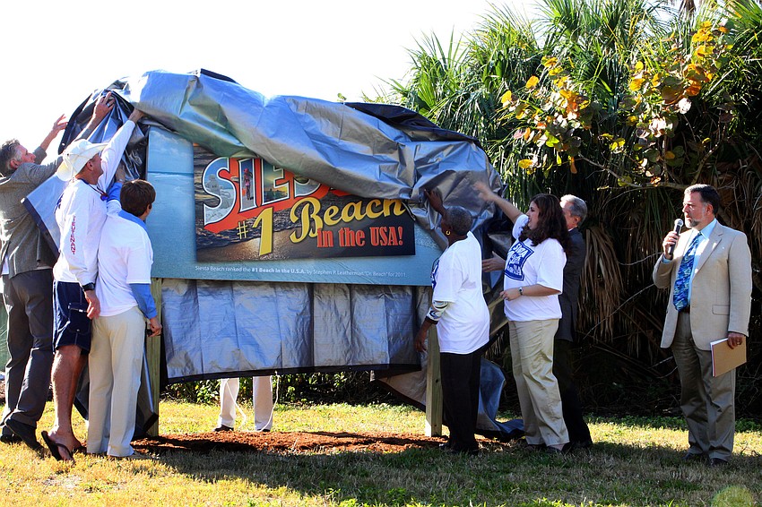 The county commissioners unveil the new sign.