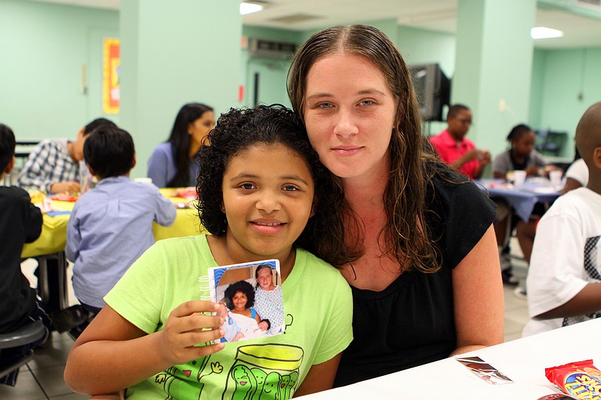 Leana Curry, 9, and her mom, Heather, work on making a book about Leana's baby sister, Serena.