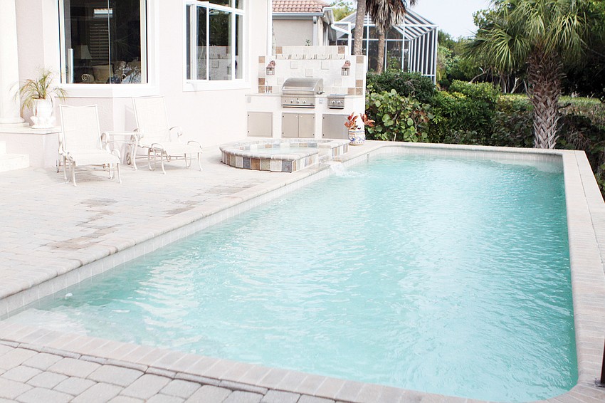 The backyard includes a pool with a grilling area that overlooks Sarasota Bay.