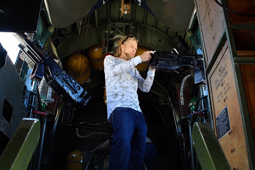 Michael Drake pretends to shoot out of â€œWitchcraftâ€ the Consolidated B-24J Liberator, Monday, Feb. 13.