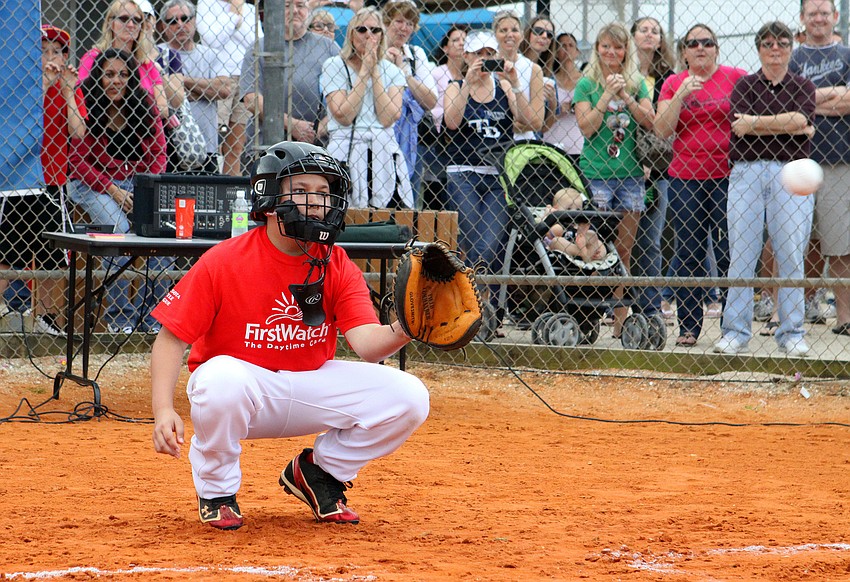 Steele Brander, 12, catches the first pitch, thrown out by Joey Terdoslavich, 23.