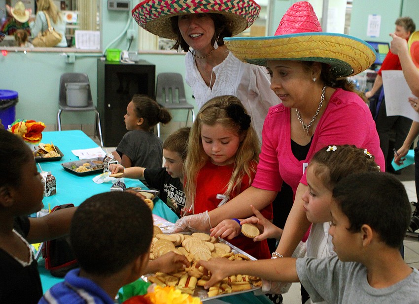 Estrella Galvan holds out a plate of desserts, Thursday, Feb. 23, during the second annual El Restaurante Bay Haven.