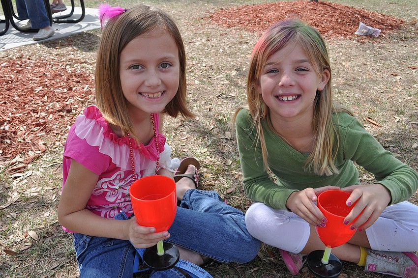 Neighbors Nicolette Woodruff and Emily Pierce made sure to use the cups they won at a booth.