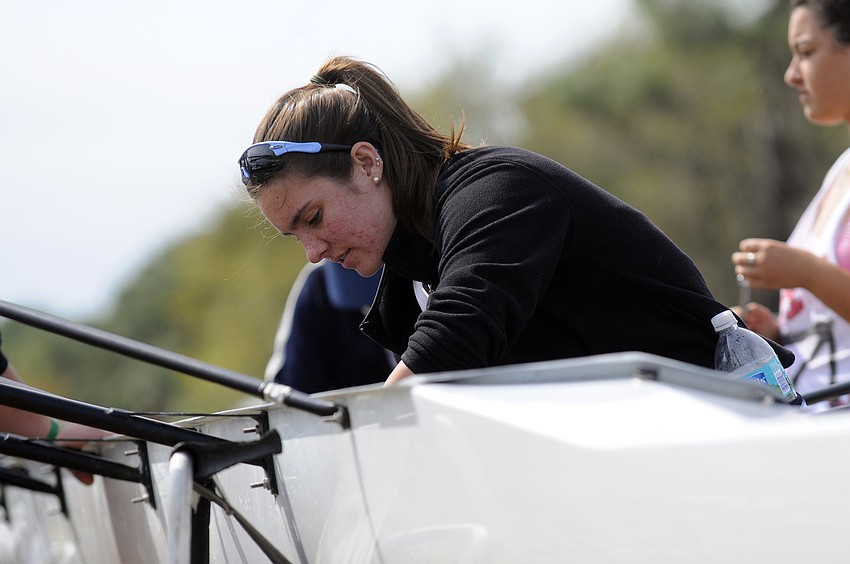 Sarasota Military Academy senior Taylor Johnson prepares her boat before the start of the Girls Novice 4+ race.