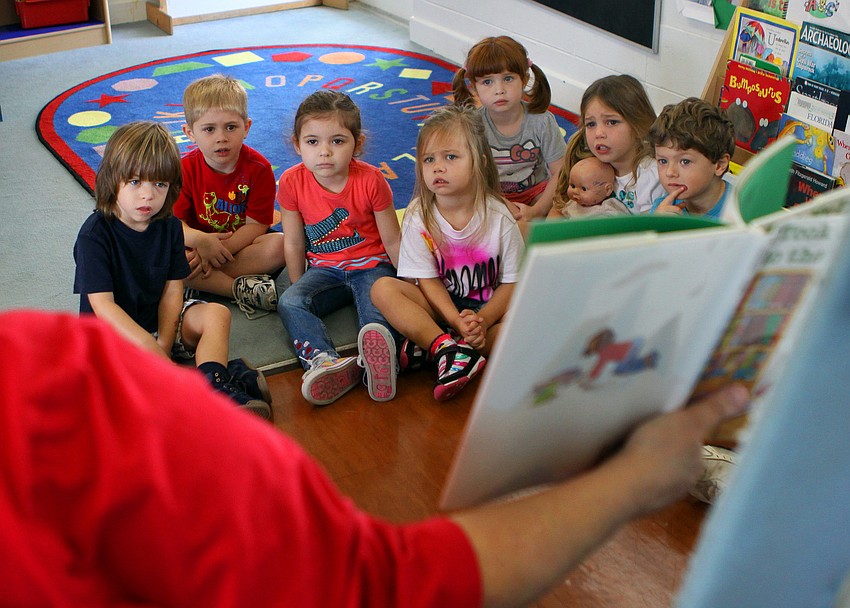 Students in the 3-4 class at St. Boniface preschool listen to Nancy Velazquez from the Gulf Gate Library read 