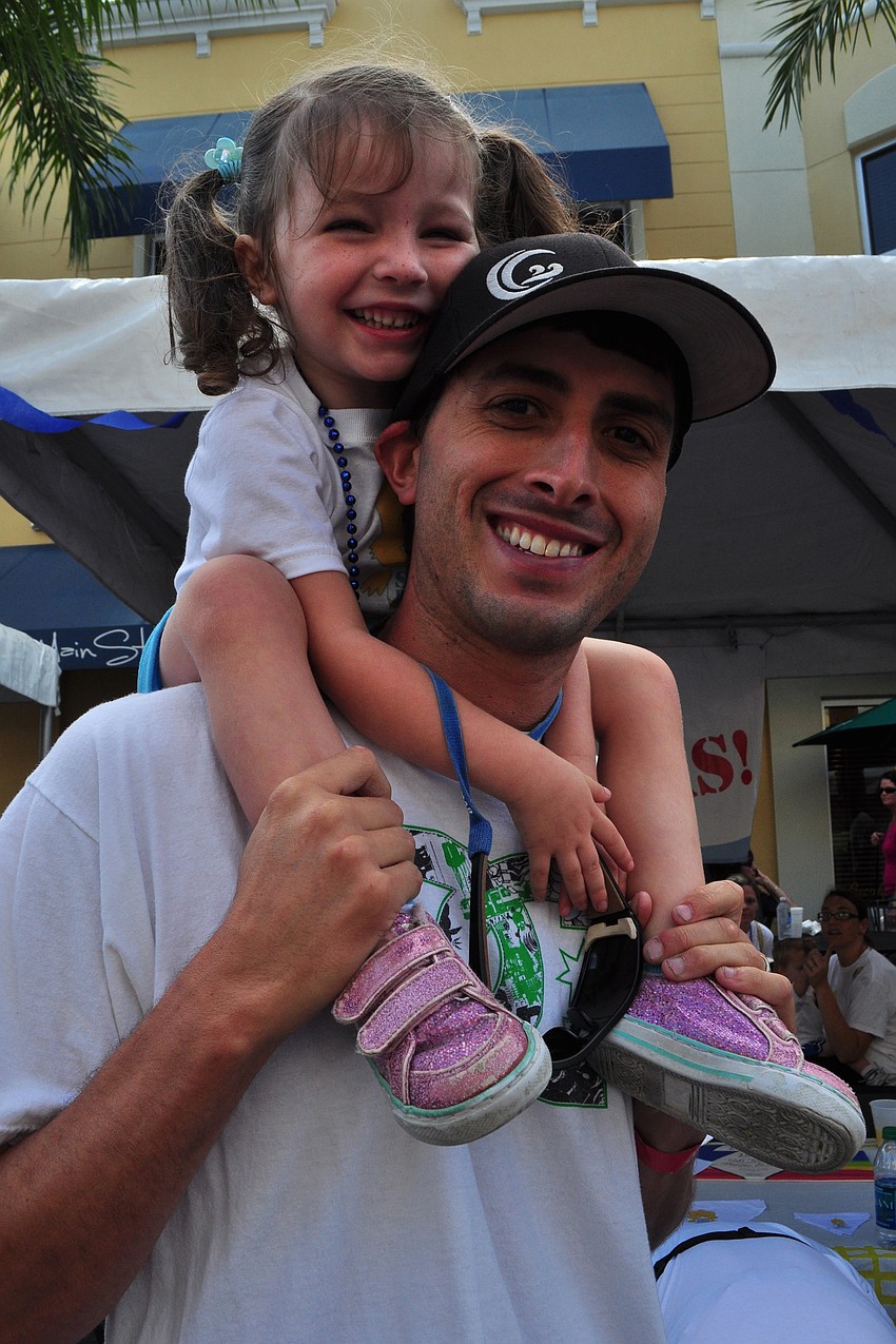 Madison Anderson, 3, watched warm up exercises from the shoulders of her dad, Dan.