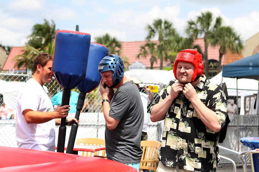 Ryan Schmidt holds the weapons as brothers Curt Platte and Jamie Platte get ready to battle one another during the Siesta Gladiator Charity Challenge, Saturday, April 14.